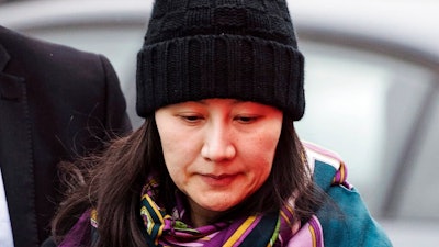 In this Dec. 12, 2018, file photo, Huawei chief financial officer Meng Wanzhou arrives at a parole office with a security guard in Vancouver, British Columbia. China on Tuesday, Jan. 22, 2019, demanded the U.S. drop a request that Canada extradite the top executive of the tech giant Huawei, shifting blame to Washington in a case that has severely damaged Beijing’s relations with Ottawa.