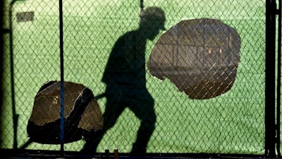 In this Nov. 14, 2018 file photo, the shadow of a worker falls on a fence at the construction site of a convenience store in Victorville, Calif. On Wednesday, Jan. 16, 2019, the Federal Reserve releases its latest 'Beige Book' survey of economic conditions. The Beige Book is based on anecdotal reports from businesses and will be considered along with other data when Fed policymakers meet next.