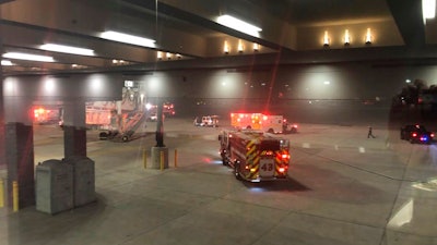 This photo provided by Lynn Krugman and taken through a window shows emergency personnel responding after an 'equipment failure' involving a jet bridge at Baltimore-Washington International Thurgood Marshall Airport, Saturday, Dec. 29, 2018, in Baltimore. Officials say several people were injured.
