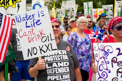 In this Aug. 6, 2017 file photo, demonstrators against the Keystone XL pipeline listen to speakers in Lincoln, Neb. Justice Department attorneys and the Canadian company behind the proposed Keystone XL oil pipeline say the U.S. government shutdown shouldn't delay a court hearing on a judge's decision to halt construction. Justice Department attorney Bridget McNeil said in a court filing Monday, Jan. 7, 20189, that federal attorneys' participation in the hearing next Monday in U.S. District Court in Great Falls isn't necessary.
