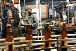 In this Jan. 14, 2019, photo, Trevor Stevens works in the bottling room at Lakefront Brewery in Milwaukee. The federal shutdown is impacting the federal agency Alcohol and Tobacco Tax and Trade Bureau, which approves licenses for new breweries, some ingredients and labels for beers sent out of state. The brewery is now waiting for the federal agency to approve the 'My Turn: Chuck' beer label, so they can sell it out of state.