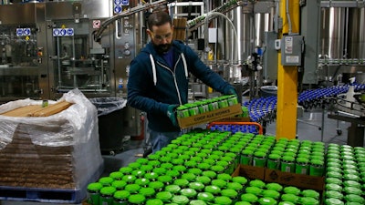 Josh Yager transfers cans of F5, one of their most popular brews, from the production line at COOP Ale Works in Oklahoma City, Friday, Jan. 18, 2019. Rules that went into effect in Oklahoma in October allow grocery, convenience and retail liquor stores to sell chilled beer with an alcohol content of up to 8.99 percent. Previously, grocery and convenience stores could offer only 3.2 percent beer. Liquor stores, where stronger beers were available, were prohibited from selling it cold.
