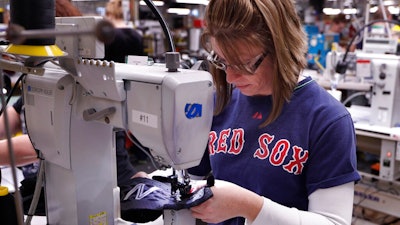 In this Monday, Dec. 17, 2018 photo, Nicole Sanborn stitches the upper section of a pair of athletic shoes designed for the military at a New Balance factory in Norridgewock, Maine. The first shipments of athletic shoes made for the U.S. Department of Defense are being shipped out. The new contract fulfills a federal law requiring the military to outfit new recruits with American-made apparel.