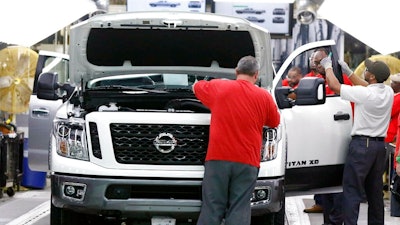 In this March 19, 2018, file photo technicians make final inspections to vehicles on the assembly line at the Nissan Canton Assembly Plant, in Canton, Miss. Nissan Motor Co. announced Thursday, Jan. 17, 2019, that it’s cutting up to 700 contract workers at its Mississippi assembly plant, citing slowing sales for vans and Titan pickup trucks that it makes there.
