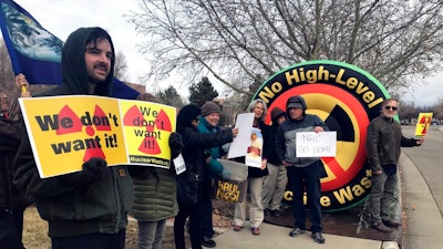 In this Tuesday, Jan. 22, 2019 photo, Brendan Shaughnessy, left, with the Nuclear Issues Study Group, protests with other activists ahead of a meeting of a U.S. Nuclear Regulatory Commission panel in Albuquerque, N.M. Environmentalists and nuclear watchdog groups are lining up against plans to build a $2.4 billion storage facility in southeastern New Mexico for spent nuclear fuel from commercial reactors around the United States.