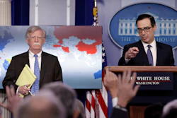 National security adviser John Bolton listens as Treasury Secretary Steven Mnuchin takes questions from reporters during a press briefing at the White House.
