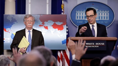 National security adviser John Bolton listens as Treasury Secretary Steven Mnuchin takes questions from reporters during a press briefing at the White House.