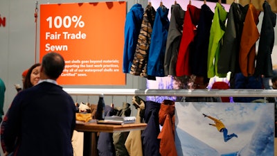 In this Wednesday, Jan. 30, 2019, photograph, a sign indicating items that were 100-percent fair trade-sewn marks a rack of jackets and shells in the Patagonia exhibit at the Outdoor Retailer & Snow Show in the Colorado Convention Center in Denver. Major players in the outdoor industry jumped into the political fight over national monuments two years ago and now have added climate change and sustainable manufacturing to their portfolio.