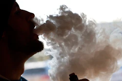Richmonder Coleman Wheeler emits a cloud of smoke from a vape pipe at a local vape shop in Richmond, Va., Friday, Jan. 18, 2019. Tobacco-friendly Virginia is preparing to raise the age limit on buying traditional and electric cigarettes from 18 to 21.