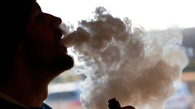 Richmonder Coleman Wheeler emits a cloud of smoke from a vape pipe at a local vape shop in Richmond, Va., Friday, Jan. 18, 2019. Tobacco-friendly Virginia is preparing to raise the age limit on buying traditional and electric cigarettes from 18 to 21.