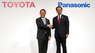 In this Dec. 13, 2017, file photo, Toyota Motor Corporation President Akio Toyoda, left, and Panasonic Corporation President Kazuhiro Tsuga, right, pose for photographers after a joint press conference in Tokyo. Toyota Motor Corp. and Panasonic Corp. said in a joint statement Tuesday, Jan. 22, 2019, they are setting up a joint venture to research, manufacture and sell batteries for ecological autos, an increasingly lucrative sector amid concerns about global warming.