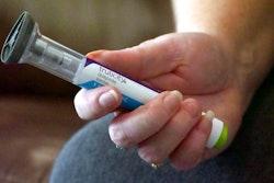 In this July 11, 2018, file photo, Bridgett Snelten holds her Trulicity injection at her home in Sandy, Utah. Drugmaker Eli Lilly has started posting price information online for drugs advertised on TV. On Tuesday, Jan. 8, 2019, the company began running TV ads for Trulicity, a popular diabetes drug, that don’t give the price but direct viewers to the website.