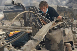 In this Oct. 9, 2017 file photo, Kristine Pond reacts as she searches the remains of her family's home destroyed by a fire in Santa Rosa, Calif. Investigators say a deadly 2017 wildfire that killed 22 people in California's wine country was caused by a private electrical system, not embattled Pacific Gas & Electric Co. The state's firefighting agency said Thursday, Jan. 24, 2019, that the Tubbs Fire started next to a residence. They did not find any violations of state law.