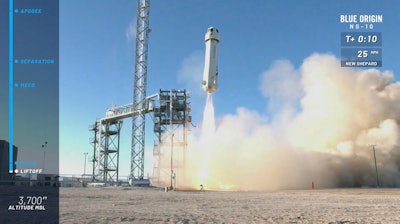 In this image from video made available by Blue Origin, the New Shepard capsule and booster lifts off from the company's site in west Texas. Jeff Bezos' rocket company launched NASA experiments into space on the brief test flight.