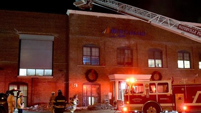 Firefighters from Waterville reach the roof of the Huhtamaki mill for a fire that had several departments respond on Tuesday evening, Jan. 29, 2019.