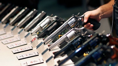 In this Jan. 19, 2016 file photo, handguns are displayed at the Smith & Wesson booth at the Shooting, Hunting and Outdoor Trade Show in Las Vegas. When gunmakers and dealers gather this week in Las Vegas for the industry's largest annual conference, they will be grappling with slumping sales and a shift in politics that many didn't envision two years ago when gun-friendly Donald Trump and a GOP-controlled Congress took office.