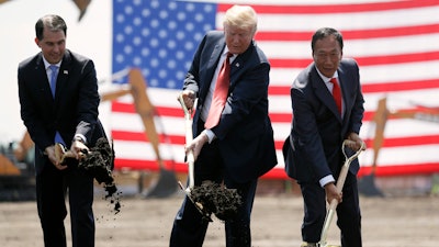 In this June 28, 2018, file photo, President Donald Trump, center, along with Wisconsin Gov. Scott Walker, left, and Foxconn Chairman Terry Gou participate in a groundbreaking event for the new Foxconn facility in Mt. Pleasant, Wis. Foxconn Technology Group said Wednesday, Jan. 30, 2019 it is shifting the focus of its planned $10 billion Wisconsin campus away from blue-collar manufacturing to a research hub, while insisting it remains committed to creating 13,000 jobs as promised.