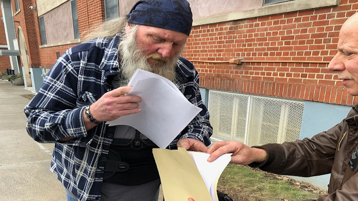 Ray Kemble, left, and Craig Stevens look through papers outside the Susquehanna County Courthouse in Montrose, Pennsylvania, on Feb. 4, 2018. A gas driller backed off its demand to have Kemble, a Pennsylvania homeowner who’s long accused the company of polluting his water, thrown in jail over his failure to submit to questioning as part of the company’s $5 million lawsuit against him.