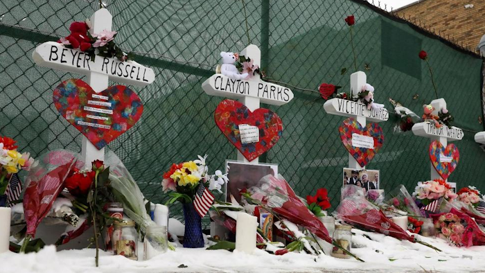 Crosses are placed for the victims of a mass shooting Sunday, Feb. 17, 2019, in Aurora, Ill., near Henry Pratt Co. manufacturing company where several were killed on Friday. Authorities say an initial background check five years ago failed to flag an out-of-state felony conviction that would have prevented a man from buying the gun he used in the mass shooting.
