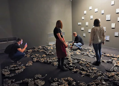 In this photo taken on Sunday, Feb. 17, 2019, visitors attend an exhibition by Russian artist Pavel Otdelnov in Moscow, Russia. Pavel Otdelnov, a Russian artist who grew up in Dzerzhinsk, the center of the nation's chemical industries 355 kilometers (220 miles) east of Moscow, focused on the city, one of the most polluted in Russia, in his new 'Promzona' art show.