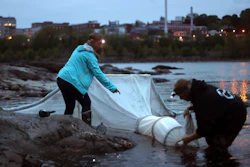 In this May 25, 2017, file photo, elver fishermen set up a net on the Penobscot River in Brewer, Maine.