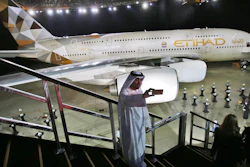 In this Dec. 18, 2014, file photo, an Emirati man takes a selfie in front of a new Etihad Airways A380 in Abu Dhabi, United Arab Emirates. Abu Dhabi-based Etihad Airways said Thursday, Feb. 14, 2019, that it has restructured planned airplane purchases from Airbus and Boeing as the government-owned carrier faces financial turbulence.