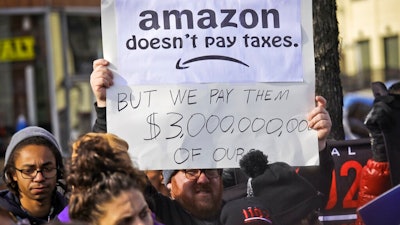 In this Nov. 14, 2018 file photo, protesters hold up anti-Amazon signs during a coalition rally and press conference of elected officials, community organizations and unions opposing Amazon headquarters getting subsidies to locate in Long Island City, in New York. Local resistance to the online retailer building part of its headquarters in Long Island City was almost immediate.