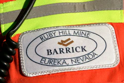 In this Feb. 14, 2006 file photo, a close-up of the chest patch of a worker at Barrick's Ruby Hill Mine, outside Eureka, Nev., is shown. Barrick Gold will try to acquire Newmont Mining Corp. in an all-stock deal that would create a mining behemoth worth about $42 billion. Newmont, based in Colorado, has shunned the Canadian miner so far, and the latest overture could become hostile. Barrick President and CEO Mark Bristow said that the two companies have highly complementary assets in Nevada, which includes Barrick’s mineral endowments and Newmont’s processing plants and infrastructure.