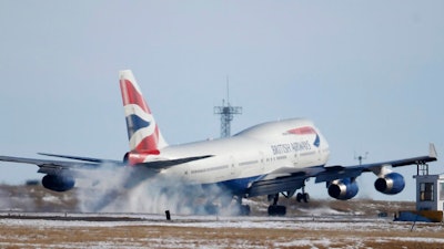 In this file photo taken late Monday, Feb. 8, 2016, a British Airways plane touches down at Denver International Airport, USA. The parent company of British Airways, International Airlines Group consortium is buying up to 42 Boeing 777 long-haul passenger jets in a multi-billion dollar deal announced Thursday Feb. 28, 2019.
