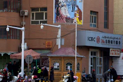 In this Nov. 5, 2017, file photo, residents pass by a security checkpoint and surveillance cameras mounted on a street in Kashgar in western China's Xinjiang region. The Chinese database Victor Gevers found online was not just a collection of old personal details. The discovery by Gevers, a Dutch cybersecurity researcher who revealed it on Twitter last week, has given a rare glimpse into China’s extensive surveillance of Xinjiang, a remote region home to an ethnic minority population that is largely Muslim. The area has been blanketed with police checkpoints and security cameras that apparently are doing more than just recording what happens. The database Gevers found appears to have been recording people’s movements tracked by facial recognition technology, he said, logging more than 6.7 million coordinates in a span of 24 hours.