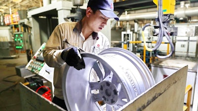 In this Monday, Feb. 11, 2019, photo, a laborer works on an aluminum wheel hub at a manufacturing facility in Qinhuangdao in northern China's Hebei province. U.S. and Chinese negotiators meet this week for their final trade talks before President Donald Trump decides whether to go ahead with a March 2 tariff hike on $200 billion of imports from China.