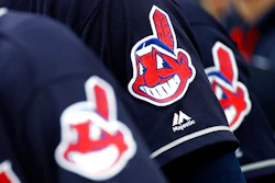 In this June 19, 2017 file photo, members of the Cleveland Indians wear uniforms featuring mascot Chief Wahoo as they stand on the field for the national anthem before a baseball game against the Baltimore Orioles in Baltimore. The maker of Cleveland's ballpark mustard is removing the Chief Wahoo logo from its branding and packaging to maintain longstanding ties with the Cleveland Indians baseball team. The Indians have told official partners like Bertman Foods Co., the maker of Bertman Original Ballpark Mustard, those relationships can't continue unless they stop using Chief Wahoo.