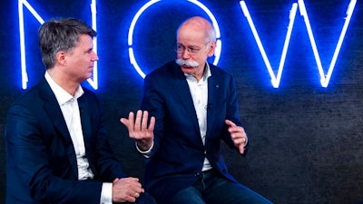 In this Friday, Feb. 22, 2019 photo Harald Krueger, left, CEO of the car manufacturer BMW, and Dieter Zetsche, right, CEO of the Daimler stock company and the car manufacturer Mercedes Benz, talk during a press conference in Berlin, Germany. Automakers BMW and Daimler said on Thursday, Feb 28, 2019 they will work together on developing the automated driving technology expected to transform the industry in the years ahead.