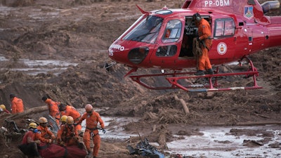 In this January 28, 2019 file photo, firefighters prepare a body to be lifted away by a helicopter in Brumadinho, Brazil.