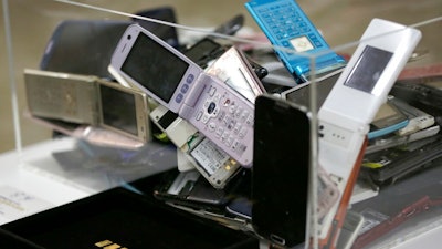 In this April 1, 2017, file photo, gold tablets of 3 grams, left, which is able to be recycled from 100 mobile phones, are shown as example in Tokyo. Tokyo Olympic organizers said in a statement Friday, Feb. 8, 2019, they expect to collect enough obsolete electronic devices by the end of March to reach the amount that will be required to manufacture all Olympic and Paralympic medals.