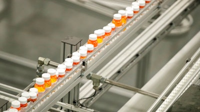 In this July 10, 2018, file photo bottles of medicine ride on a belt at the Express Scripts mail-in pharmacy warehouse in Florence, N.J. As Democrats in Congress consider whether to back a revamped regional trade pact being pushed by President Donald Trump, they’re zeroing in on a new point of conflict: Drug prices. They contend that the new pact would force Americans to pay more for prescription drugs, and their argument has dimmed the outlook for one of Trump’s signature causes.