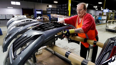 This Wednesday, Nov. 28, 2018 file photo shows Clifford Goff, a bezel assembler, transferring a front end of a General Motors Chevrolet Cruze during assembly at Jamestown Industries, in Youngstown, Ohio. The sting from a major restructuring coming this year at General Motors is sure to be felt far beyond the five North American factories that are slated to close in the coming months. Thousands of jobs at auto parts suppliers and other industry-related positions are at stake as well.