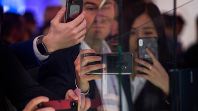 Attendees take pictures of the new Huawei Mate X foldable 5G smartphone during the Mobile World Congress wireless show, in Barcelona, Spain, Monday, Feb. 25, 2019. The annual Mobile World Congress (MWC) runs from 25-28 February in Barcelona, where companies from all over the world gather to share new products.