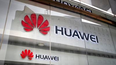 In this Jan. 29, 2019, file photo, the logos of Huawei are displayed at its retail shop window reflecting the Ministry of Foreign Affairs office in Beijing. The head of Britain's cybersecurity agency says government oversight of Huawei has proven it can flag up security problems, suggesting he doesn't think the Chinese company needs to be banned from supplying mobile networks. Ciaran Martin, the CEO of the National Cyber Security Centre, also said Wednesday, Feb. 20, 2019 that one of the conditions for maintaining good cybersecurity is having 'sustainable diversity' in the telecommunications equipment supplier market.