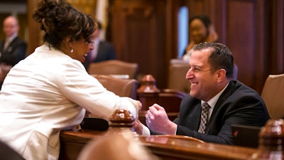State Sen. Michael Hastings, D-Tinley Park, right, gets a fist bump from Sen. Toi Hutchinson, D-Chicago Heights, after delivering his remarks on Senate Bill 1, a bill to raise the state's minimum wage to $15 an hour by 2025, during debate on the Senate floor at the Illinois State Capitol, Thursday, Feb. 7, 2019, in Springfield, Ill.