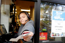 In this Jan. 3, 2019, file photo a cashier returns a credit card and a receipt at a McDonald's window, where signage for job openings are displayed in Atlantic Highlands, N.J. On Tuesday, Feb. 12, the Labor Department reports on job openings and labor turnover for December.