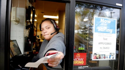 In this Jan. 3, 2019, file photo a cashier returns a credit card and a receipt at a McDonald's window, where signage for job openings are displayed in Atlantic Highlands, N.J. On Tuesday, Feb. 12, the Labor Department reports on job openings and labor turnover for December.