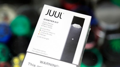 This Thursday, Dec. 20, 2018 file photo shows a Juul electronic cigarette starter kit at a smoke shop in New York. According to letters released on Friday, Feb. 8, 2019, the head of the Food and Drug Administration is questioning whether electronic cigarette maker Juul and its new partner Altria are following through on pledges to help reverse the current epidemic of underage vaping.
