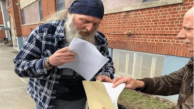 Ray Kemble, left, and Craig Stevens look through papers outside the Susquehanna County Courthouse in Montrose, Pennsylvania, on Feb. 4, 2018. A gas driller backed off its demand to have Kemble, a Pennsylvania homeowner who’s long accused the company of polluting his water, thrown in jail over his failure to submit to questioning as part of the company’s $5 million lawsuit against him.