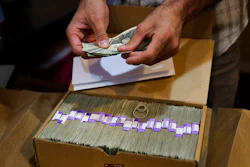 In this June 27, 2017 file photo, the proprietor of a medical marijuana dispensary prepares his monthly tax payment, over $40,000 in cash, at his Los Angeles store. Congress on Wednesday, Feb. 13, 2019, was urged to fully open the doors of the nation's banking system to the legal marijuana industry, a change that supporters say would reduce the risk of crime and resolve a litany of problems for pot companies from paying taxes to getting a loan.