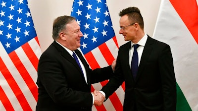 Hungarian Minister of Foreign Affairs and Trade Peter Szijjarto, right, shakes hands with US Secretary of State Mike Pompeo in the ministry in Budapest, Hungary, Monday, February 11, 2019. Pompeo is on an official visit to Hungary.