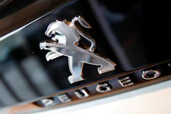 In this Feb.23, 2017 file photo, the logo of French automaker Peugeot is pictured during the presentation of the company's 2016 full year results, in Paris. The French maker of Peugeot automobiles plans to reintroduce the cars to North American markets. The company said Tuesday, Feb. 26, 2019, that the move is part of a ten-year plan announced in 2016, which includes a car sharing service of more than 500 vehicles introduced in Washington, D.C., last year.