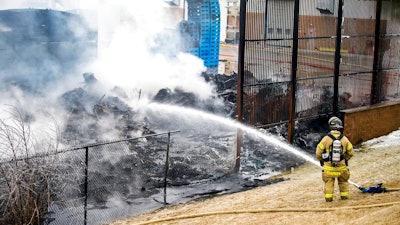 A lone firefighter contains a large blaze near the U.S. Farathane Corporation building, a plastics and manufacturing supply facility, on Tuesday, Feb. 26, 2019 in Auburn Hills, Mich. No injuries were reported.