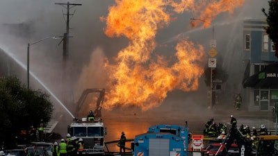 San Francisco firefighters battle a fire on Geary Boulevard in San Francisco. A gas explosion in a San Francisco neighborhood shot flames high into the air Wednesday and was burning several buildings as utility crews scrambled to shut off the flow of gas.
