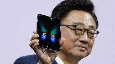 DJ Koh, President and CEO of IT and Mobile Communications, holds up the new Samsung Galaxy Fold smartphone during an event Wednesday, Feb. 20, 2019, in San Francisco.